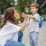 A mom sending her son to school with a good-bye high-five.