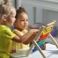 Children sit together at the table and count on the abacus.