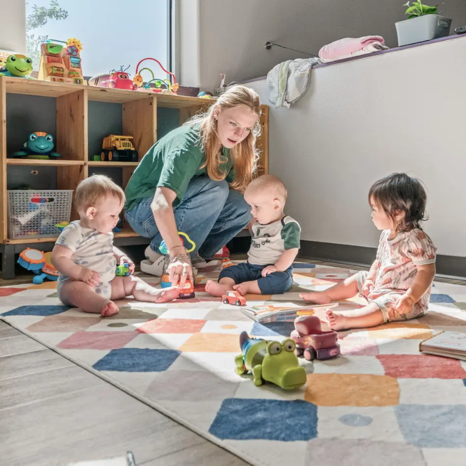 A teacher playing with toddlers.